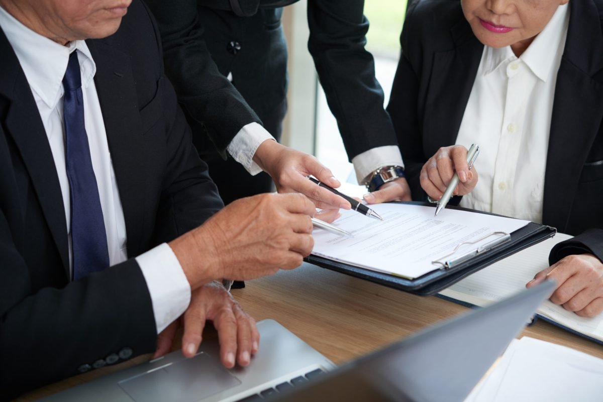 Business people reading contract terms at the meeting